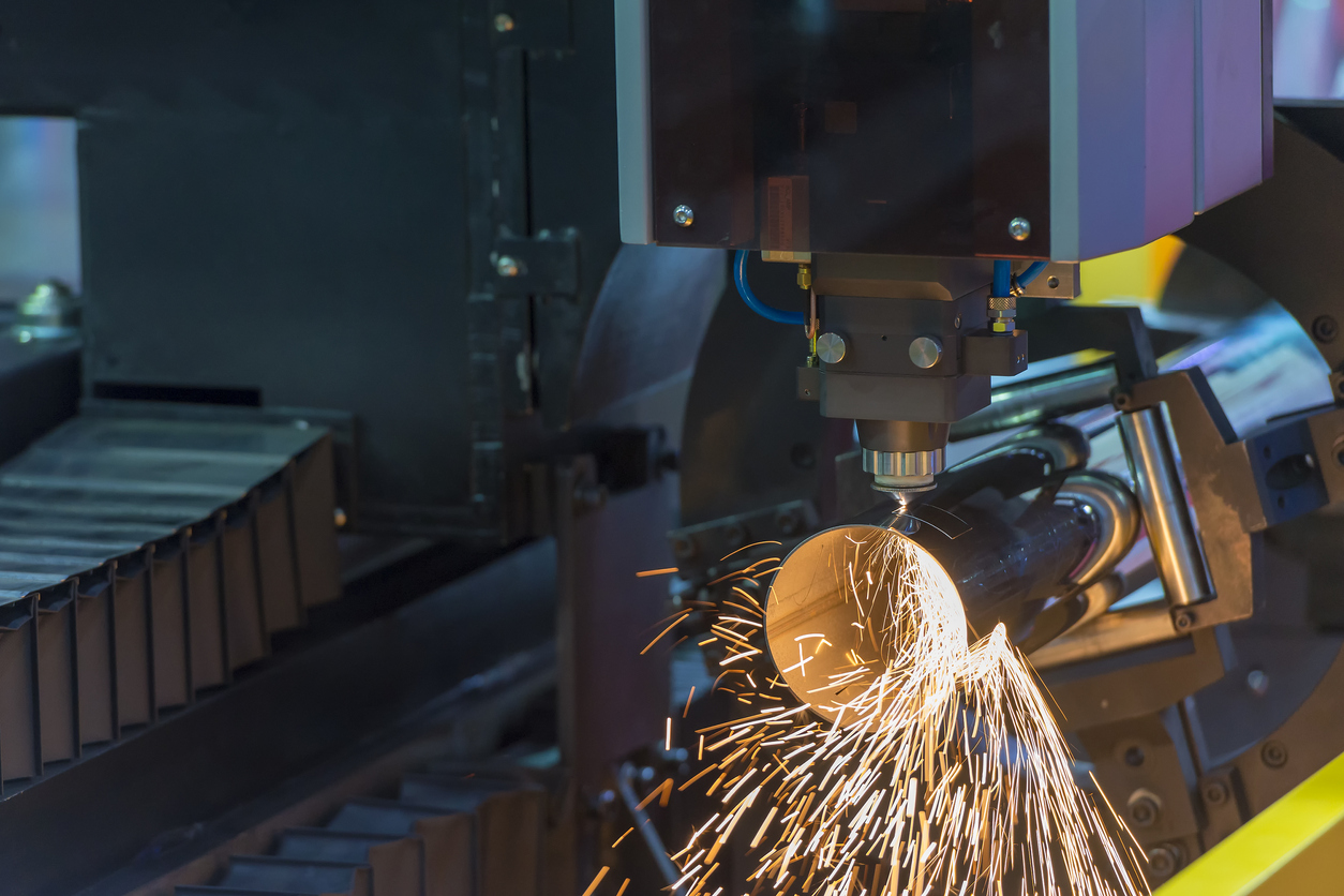 Industrielle Maschine schneidet Metallrohr, Funken fliegen